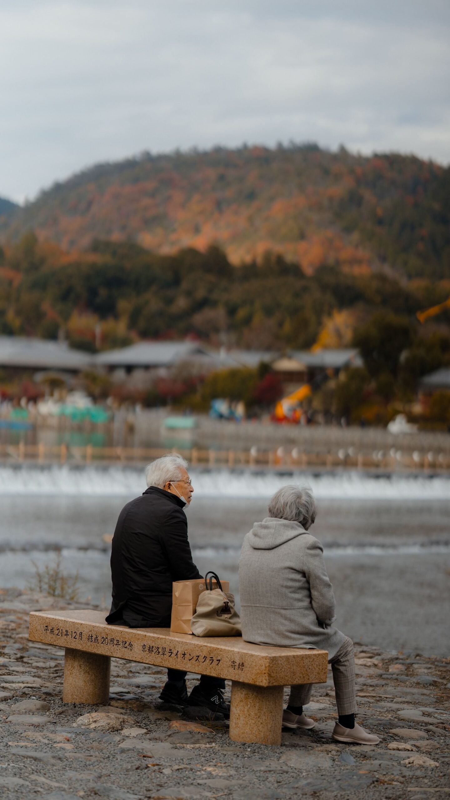 日本京都河边的老人夫妇，象征养老和介护规划